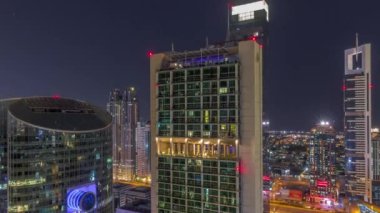 Dubai Uluslararası Finans Merkezi gökdelenleri tüm gece boyunca havalanır. Işıkların yukarıdan kapatıldığı aydınlık kuleler. Ay batıyor