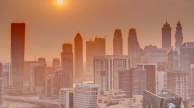 Günbatımında Dubai iş alanı kulelerinin modern mimarisi ile Skyline. Kanal ve şantiyeli hava manzarası