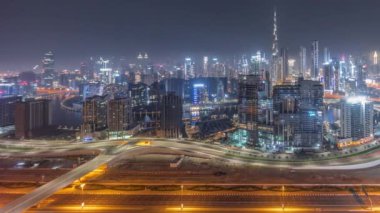 Tüm gece boyunca Dubai 'nin panoramik silueti, iş sahasında ve şehir merkezinde. Birçok modern gökdelenin ve Al Khail yolundaki yoğun trafiğin havadan görüntüsü. Ay batıyor ve ışıklar yanıyor