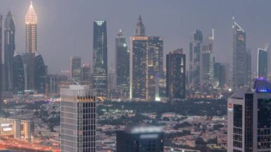 Dubai 'nin finans bölgesindeki gökdelenler gündüzden geceye geçiş zamanı. Business Bay bölgesinden birçok kuleye panoramik manzara