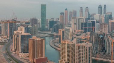 Dubai iş sahası kulelerinin modern mimarisine sahip Skyline sabah zaman çizelgesi. Gün doğumunda kanal ve şantiyeli hava manzarası
