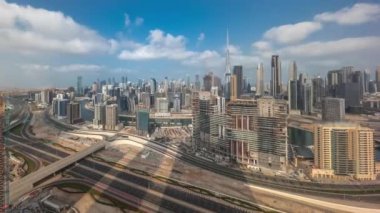 Dubai 'nin panoramik silueti, iş sahasında ve şehir merkezinde Al Khail yolunda trafik varken. Bulutlu mavi gökyüzüne karşı birçok modern gökdelenlerin gölgeleriyle hava manzarası. Birleşik Arap
