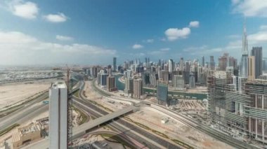Panorama Dubai 'nin ufuk çizgisini iş sahası ve şehir merkezi zaman çizelgesiyle gösteriyor. Bulutlu mavi gökyüzü olan birçok modern gökdelenin havadan görünüşü. Birleşik Arap Emirlikleri.