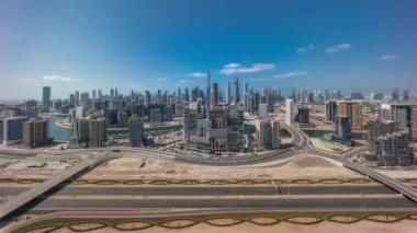 Dubai 'nin panoramik ufuk çizgisi. İş sahası ve şehir merkezi tüm gün boyunca. Gölgeleri hızlı hareket eden ve otoyolda trafiği olan birçok modern gökdelenin havadan görünüşü. Birleşik Arap