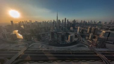 Dubai 'nin panoramik ufuk çizgisi üzerinde gün batımı iş sahası ve şehir merkezi zaman çizelgesi. Turuncu gökyüzü olan birçok modern gökdelenlerin yukarıdan görünüşü. Birleşik Arap Emirlikleri.