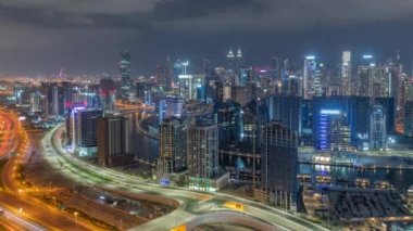 Dubai 'nin modern mimarisine sahip Skyline tüm gece panoramik zaman dilimi boyunca kuleleri aydınlattı ve ışıklar söndü. Kanal ve şantiyeli hava manzarası
