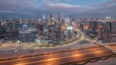 Dubai 'nin panoramik ufuk çizgisi. Gece gündüz iş sahası ve şehir merkezi geçiş zamanı. Gündoğumundan önce otoyolda trafik varken birçok modern gökdelenin havadan görünüşü. Birleşik Arap