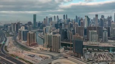 Dubai iş sahası kulelerinin modern mimarisine sahip Skyline sabah zaman çizelgesi. Gün doğumunda bulutlu gökyüzü ile birlikte kanal ve inşaat alanında hava panoramik görüntüsü
