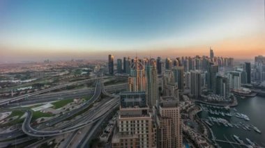 Dubai marinası ve JLT gökdelenleri Sheikh Zayed Yolu boyunca günden geceye geçiş zamanı. Gün batımında yukarıdan ev ve ofis binaları manzarası