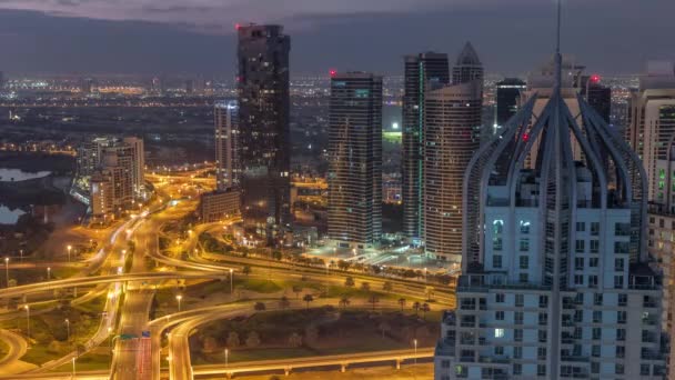 Jlt区与迪拜码头之间的巨大公路交叉口 由谢赫扎耶德路空中穿越 夜以继日的过渡时间 靠近照明塔和摩天大楼的高尔夫球场 — 图库视频影像