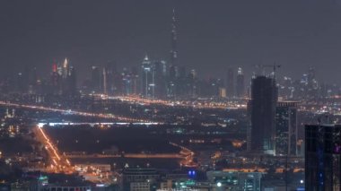 Dubai Şehir Merkezi 'nin finans bölgesi ufuk çizgisi en yüksek gökdelenli gökdelenler tüm gece boyunca en yüksek kule antenli ve ışıkları kapalı. Dubai yat limanının çatısından çok uzakta.