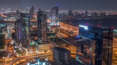 Dubai marinasından tüm gece boyunca Media City ve Al Barsha Tepeleri 'nin hava görüntüsü. Işıkları sönen gökdelenler ve gökdelenler ve yukarıdan gelen bir otoyolda trafik