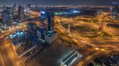 Media City bölgesinin ve karayolu kavşağının tüm gece boyunca Dubai marinasından panoramik görüntüsü ve ışıkları kapalı. Gökdelenler ve gökdelenler, yukarıdan otoyol trafiği