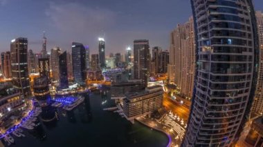 Dubai marinasına açılan hava manzarası kanalın etrafındaki gökdelenleri gece gündüz yüzen yatlarla aydınlattı. Güneş doğmadan önce beyaz tekneler yat kulübüne park edilir.