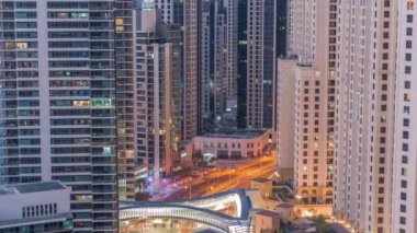 JBR ve Dubai Marina gökdelenleri, deniz kenarındaki gökdelenler, gece gündüz geçiş zamanlarına göre havadan apartmanlar. Yol kavşağında trafik ve yaya geçidi