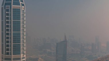 Dubai Havacılık, Dubai marinasından tüm gün boyunca Al Barsha Tepeleri ve Yeşiller Bölgesi 'nde sis olduğunu gösteriyor. Gökdelenler ve kuleler Yukarıdan sisli bir gün