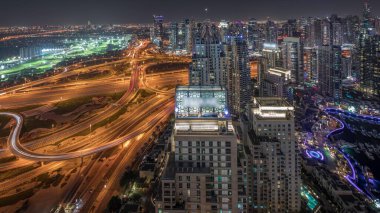 Dubai marinası ve JLT 'nin Sheikh Zayed Yolu boyunca gökdelenleri aydınlattığı panorama büyük kavşak ve Medya Şehri hava sahaları gece zaman çizelgesi ile gösteriliyor. Yukarıdan konut ve ofis binaları.