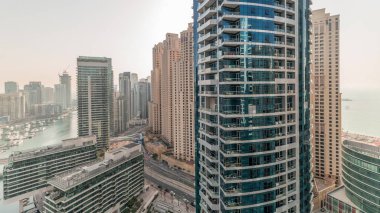 Panorama, JBR ve Dubai Marina gökdelenlerinin gökdelenlerinin gökdelenlerini gösteriyor. Kanal suyunda yüzen yatlar. Arka planda JLT bölgesi