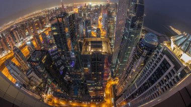 Dubai Marina 'nın gökdelenleri kıyı şeridi boyunca gece gündüz geçiş zamanları boyunca aydınlık gökdelenlerle çevrili. Gün doğarken caddelerin en yüksek kuleleri ve trafiği. Dubai, BAE