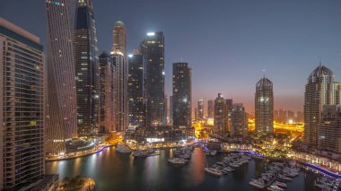 Dubai marinası en uzun gökdelenler ve yatlar liman havasında gece gündüz geçiş zamanları gün doğumunda. Apartman binalarına, otellere ve ofis bloklarına, BAE 'nin modern yerleşim alanlarına bak
