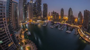 Dubai marinası en uzun gökdelenler ve yatlar liman havasında gece gündüz geçiş panoramik zaman dilimi güneş doğmadan önce. Apartman binalarına, otellere ve ofis bloklarına, BAE 'nin modern yerleşim alanlarına bak