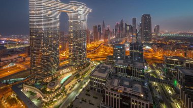 Fütürist Dubai Şehir Merkezi ve finans bölgesi gökyüzü gece gündüz geçiş zamanı. Güneş doğarken caddelerde trafik olan birçok kule ve gökdelen var.