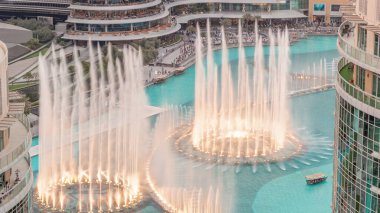 Dubai 'de havadan zaman ayarlı yürüme alanı olan çeşmeler. İnsanlar gün batımında alışveriş merkezinin yakınındaki şovu izliyor