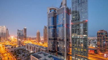 Dubai Uluslararası Finans Bölgesi 'nin hava görüntüsü. Günbegün geçiş zamanı birçok gökdelen var. Yanan kuleleri olan park yeri yakınındaki bir yolda trafik vardı. Dubai, BAE.