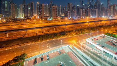 Dubai marinası gece gündüz gökdelenlerin en yüksek bloğu gün doğumundan önce geçiş zamanı. JLT bölgesinden apartman binalarına, otellere ve otoyol yakınlarındaki iş kulelerine hava manzarası.