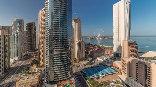 Panorama showing Dubai Marina and JBR area and the famous Ferris Wheel aerial timelapse and golden sand beaches in the Persian Gulf at the morning
