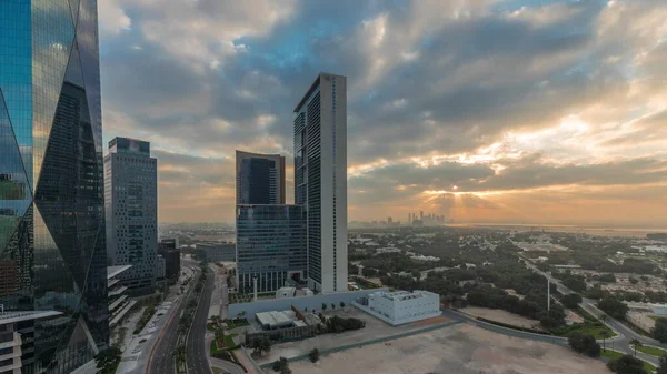 Sunrise in Dubai International Financial district transition timelapse. Panoramic aerial view of business office towers at morning. Skyscrapers with hotels and shopping malls near downtown