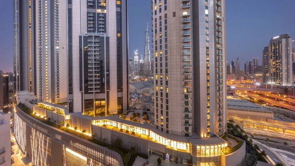 Tallest skyscrapers in downtown dubai located on bouleward street near shopping mall aerial night to day transition timelapse. Walking area with rooftop gardens before sunrise