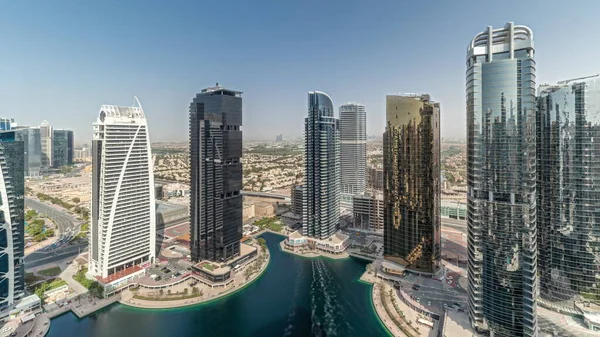 Panorama showing tall residential buildings at JLT district aerial timelapse, part of the Dubai multi commodities centre mixed-use district. Villa houses on a background