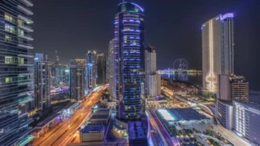 Dubai Marina ve JBR bölgesinin panoramik manzarası ve ünlü dönme dolap. Tüm gece boyunca gökdelenler aydınlandı ve ışıklar söndü.