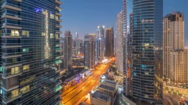 Dubai Marina ve JBR bölgesinin manzarası ve gece gündüz hava trafiği geçiş zamanları ve gün doğumundan önce aydınlatılmış gökdelenler