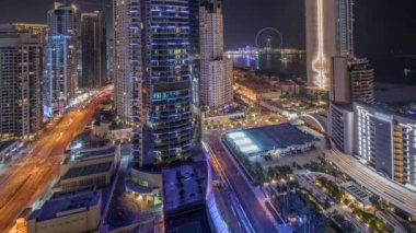 Tüm gece boyunca Dubai Marina ve JBR bölgesinin panoramik görüntüsü. Meşhur dönme dolap gece zaman ayarlı ve ışıkları sönen aydınlık gökdelenler.