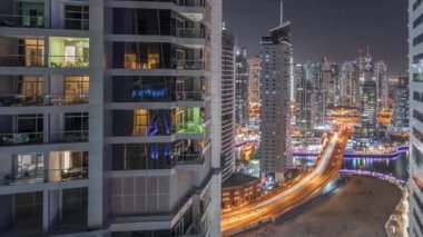 Dubai Marina 'da aydınlık gökdelenler ve limandaki en lüks yat arasındaki hava manzarası. Rıhtımdaki yürüme alanı boyunca kuleler. Dubai, Birleşik Arap Emirlikleri