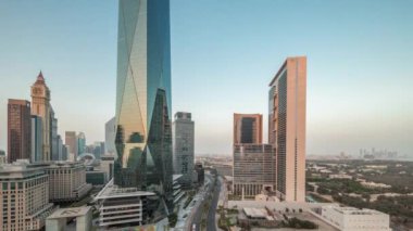 Dubai Uluslararası Finans Bölgesi, günden geceye geçiş zamanı. Gün batımından sonra panoramik ofis kulesi manzarası. Şehir merkezine yakın bir yolda otelleri ve trafiği olan gökdelenler.