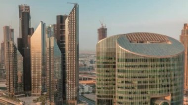 Dubai Uluslararası Finans Merkezi gökdelenleri havadan sabah zaman çizelgesi. Güneş doğarken yukarıdan sıcak güneş ışığı gören kuleler.