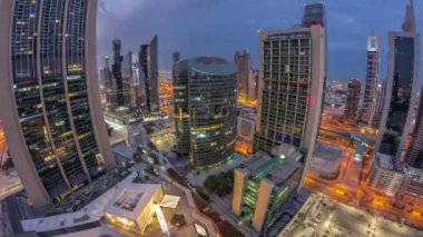 Dubai Uluslararası Finans Merkezi gökdelenlerinin panoraması gece gündüz geçiş zamanı. Aydınlatılmış kuleler güneş doğmadan önce yukarıdan görünür