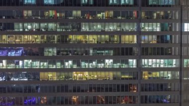Geceleri ofis binalarının pencereleri, gökdelenlerin pencerelerinden gelen ışık. Parlak çalışma alanı olan şehrin akşam manzarası
