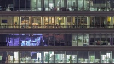 Ofis binalarının gece saatlerinde pencereleri gökdelenlerin pencerelerinden gelen ışık manzarayı kapatıyor. Şehrin akşam manzarası ışıl ışıl çalışıyor.