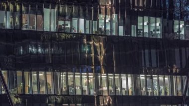 Geceleri ofis binalarının pencereleri, gökdelenlerin panoramik pencerelerinden gelen ışık. Parlak çalışma alanı olan şehrin akşam manzarası