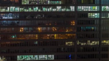 Ofis binalarının pencereleri gece gündüz geçiş zamanları, sabahları gökdelenlerin pencerelerinden sarkan ışıklar. Parlak çalışma alanı olan şehrin manzarası