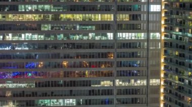 Tüm gece boyunca ofis binalarının pencereleri, gökdelenlerin pencerelerinde ışıkların kapanması. Parlak çalışma alanı olan şehrin akşam manzarası