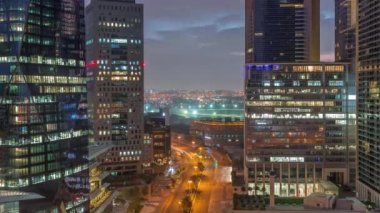 Dubai Uluslararası Finans Bölgesi gece gündüz geçiş zamanı. Gün doğmadan önce iş yerinin gökyüzü manzarası. Yol trafiğiyle aydınlanan gökdelenler ve Deira ilçesi