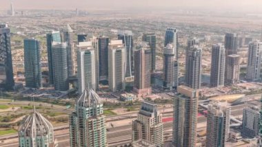 Dubai marina kuleleri ve JLT bölgesi. Şeyh Zayed yolu üzerinde metro istasyonunun yakınındaki trafik. Gölgeler hızla ilerliyor. Yukarıdan aşağıya bak, gökdelenler çatılar, Birleşik Arap Emirlikleri.