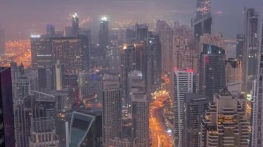 Dubai Marina 'nın Vew' ı, kıyı şeridi boyunca aydınlık gökdelenlerle çevrili kanalı gösteriyor. Gece gündüz geçiş zamanı. Güneş doğmadan önce yüzen yatlar ve tekneler. Dubai, BAE