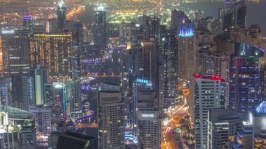 Dubai Marina 'nın Skyline görüntüsü tüm gece boyunca kıyı şeridi boyunca aydınlık gökdelenlerle çevrili kanalı gösteriyor. Yüzen yatlar ve tekneler. Işıklar kapanıyor. Dubai, BAE