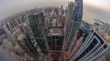 Dubai Marina 'nın gökdelenlerle çevrili Skyline panoraması kıyı şeridi boyunca gün boyunca gece geçiş zamanı boyunca kanalı gösteriyor. Gün batımından sonra yüzen yatlar ve tekneler. Dubai, BAE
